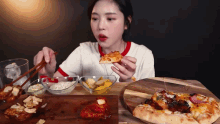 a woman is sitting at a table eating pizza