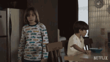 two children are sitting at a table with a bowl of cereal and a netflix logo in the corner