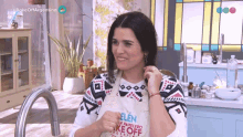 a woman wearing a white apron that says bake off argentina