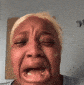 a woman is crying with her eyes closed and her mouth open .