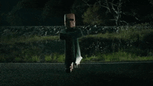 a person is flying through the air over a road at night .
