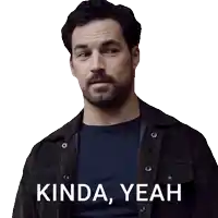 a man with a beard is wearing a black shirt and a brown jacket with kinda yeah written on it