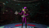 a purple and blue monster with sharp teeth looks at the camera in a dark room
