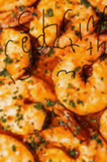 a close up of a pile of shrimp with sauce and parsley on a plate .