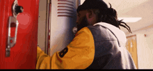a man in a yellow jacket with the letter b on the sleeve