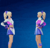 two cheerleaders are standing next to each other and one is wearing a purple top