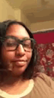 a woman wearing glasses is taking a selfie with her eyes closed .