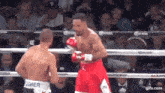 two men are fighting in a boxing ring and one of them is wearing jordan boxing gloves .