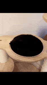 a black cat is sleeping on a wooden shelf
