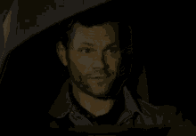a man is smiling in a dark room