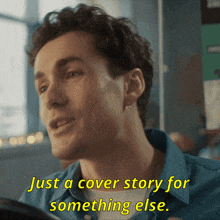 a man in a blue shirt is talking about a cover story for something else