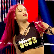 a woman with pink hair is wearing a top that says boss
