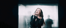 a woman singing into a microphone with a blurred background