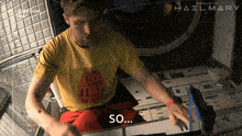 a man in a yellow shirt is sitting in a room with the words so on the bottom
