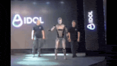 a robot is dancing on a stage in front of an idol sign