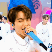 a man singing into a blue microphone with the word lje on the bottom