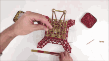 a person is building a model of the eiffel tower with magnetic sticks