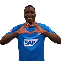 a man wearing a blue shirt with the word sap on it makes a heart shape with his hands