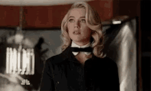 a woman in a tuxedo and bow tie is standing in a room .