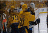a hockey player with the number 59 on his jersey talks to another player
