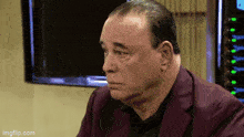 a man in a purple suit is looking at something