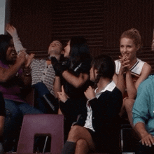 a group of people sitting in a row with one wearing a shirt that says ' i love you '