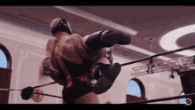 a wrestler is carrying another wrestler on his back in a ring