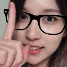 a woman wearing glasses giving a thumbs up