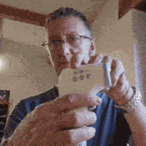 a man with glasses is holding a thermometer in his hands