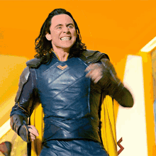 a man in a superhero costume with a yellow cape is smiling