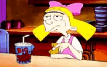 a cartoon character is sitting at a table with a cup that says big