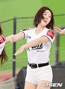a woman in a baseball uniform is dancing on the field .