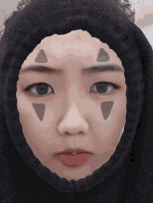 a close up of a woman 's face with triangles painted on her face