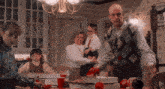 a group of people are gathered around a table with pizza boxes