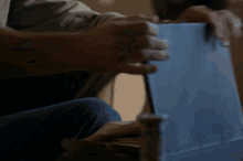 a person is holding a piece of blue paper