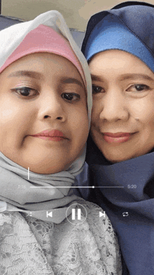 a video of two women is being played with a pause button