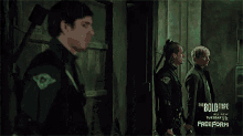 a man and woman are standing in a dark room with the bold type written on the wall