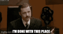a group of people sitting around a table with the words " i 'm done with this place " on the screen