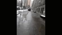 a black and white photo of a snowy street with a building in the background
