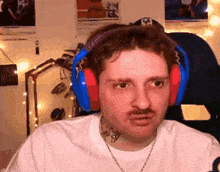 a man with a mustache wearing headphones and a white shirt