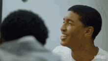 a man is smiling in front of a mirror with mars reel written on his shirt