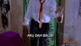a man in a white shirt and red tie is holding a jar with the word af on it