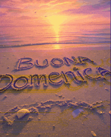the words buona domenica are written in the sand on a beach