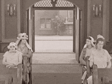 a black and white photo of a group of women sitting in a room
