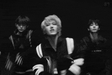 a group of young men are dancing in a black and white photo .