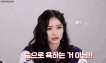 a woman with long black hair is wearing a purple and white jacket and talking in korean .
