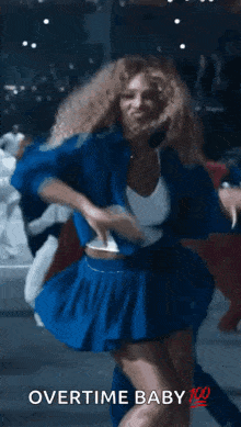 a woman in a blue skirt is dancing with the words overtime baby 100 written on the bottom .