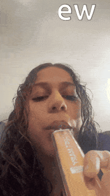 a woman is holding a bottle of l' oreal in her mouth .