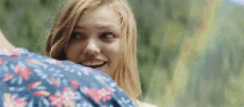 a woman is smiling while looking over the shoulder of a man .