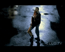 a man is holding a woman in his arms in a video from ello tv